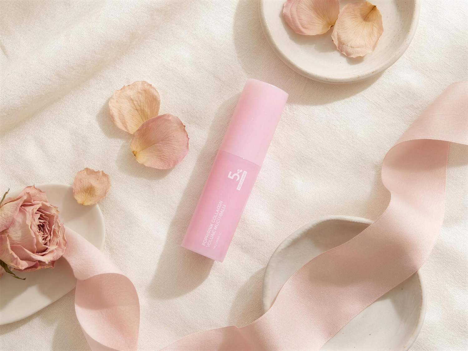 Aurelly Collagen Glow Multi-Balm flat lay with rose petals and silk ribbon